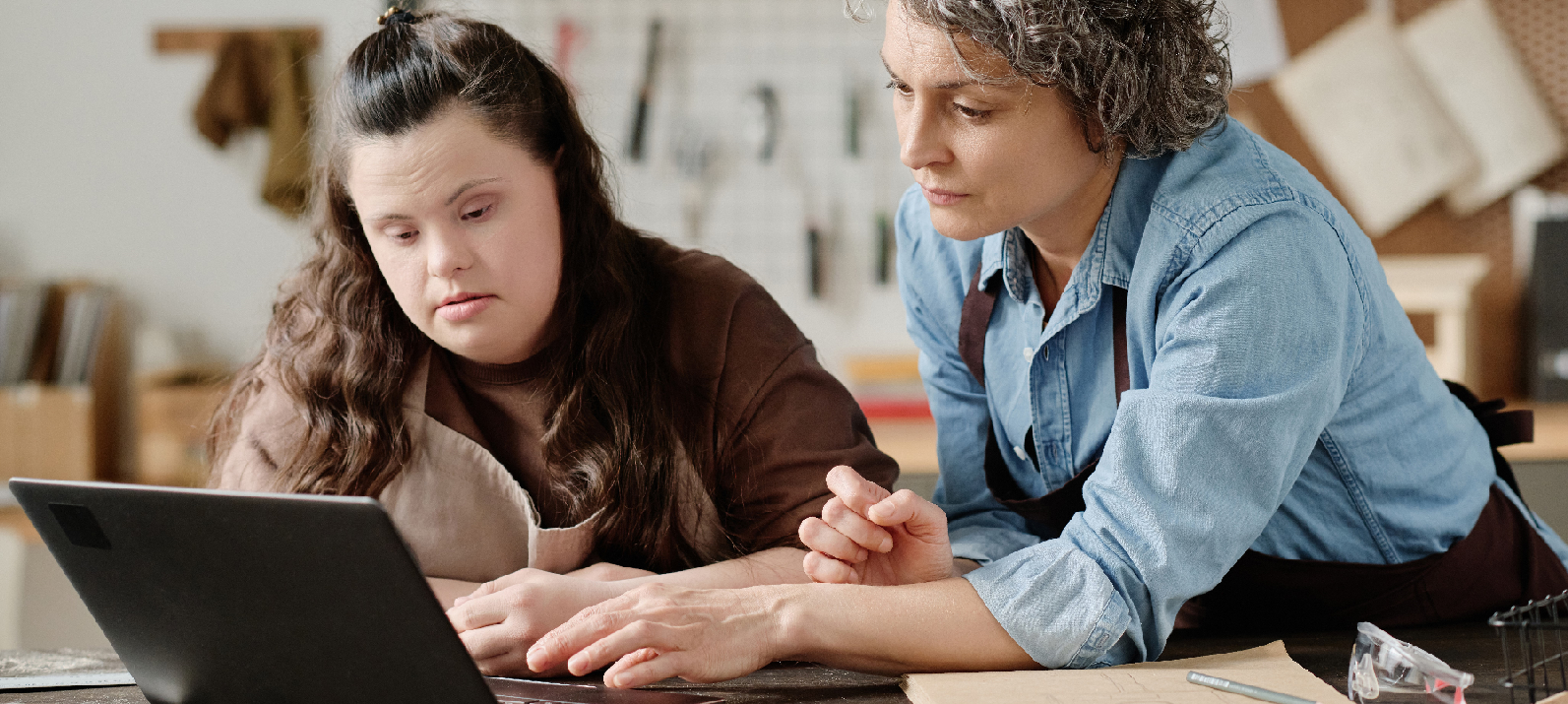 women woodworking together and viewing a course online